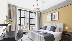A modern hotel room with a large bed, a desk, and a view of the city through large windows. - Silkhaus Standpoint, Downtown Dubai (Dubai)