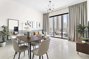 A modern living room with a dining area, large windows with curtains, and city views. - Silkhaus Standpoint, Downtown Dubai (Dubai)