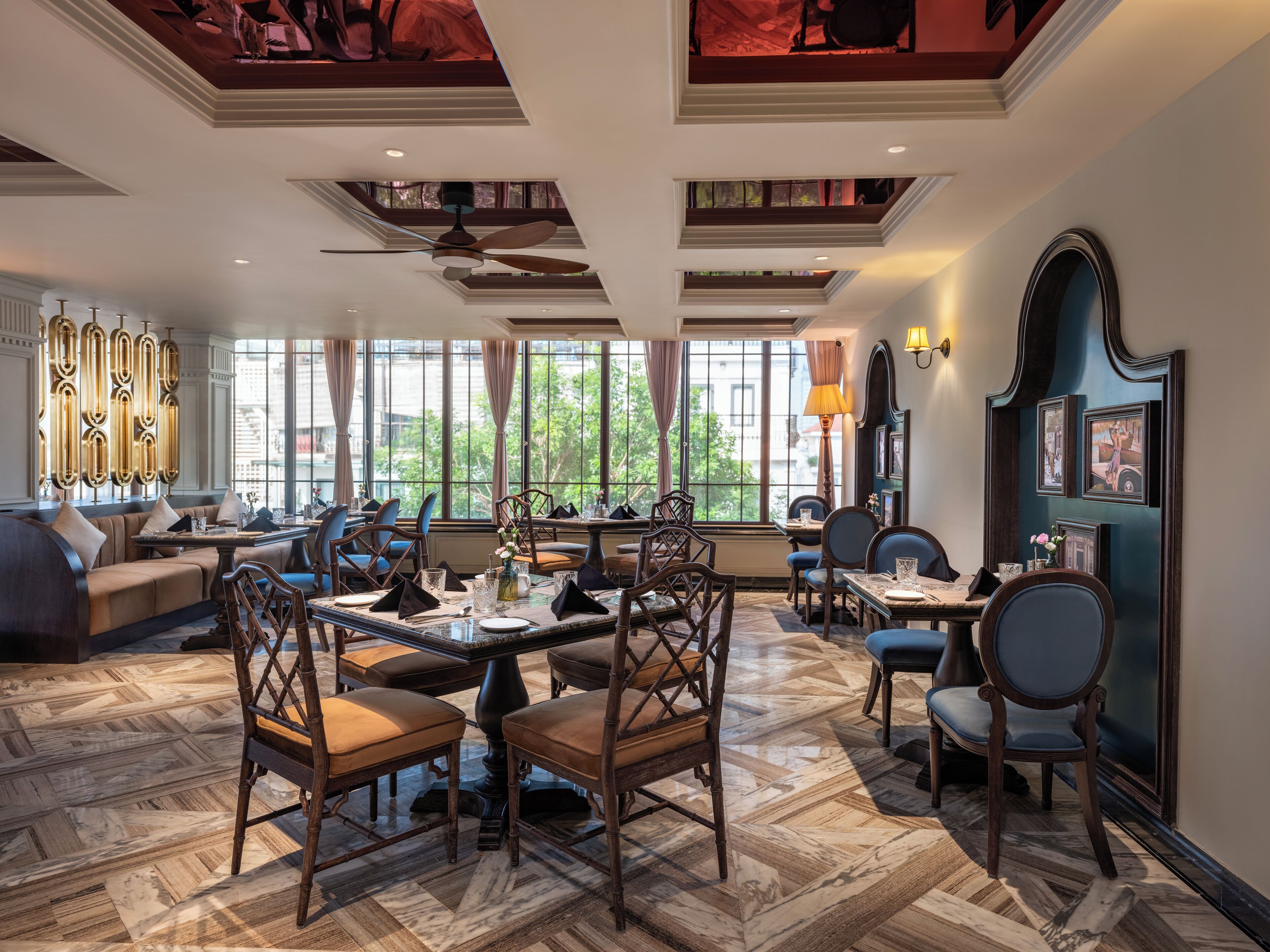 A spacious dining area with high ceilings, large windows, and a mix of modern and classic furniture.