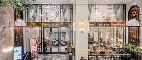 The entrance of the Grand du Lac hotel with a marble staircase, a concierge desk, and a view of the lobby area.
