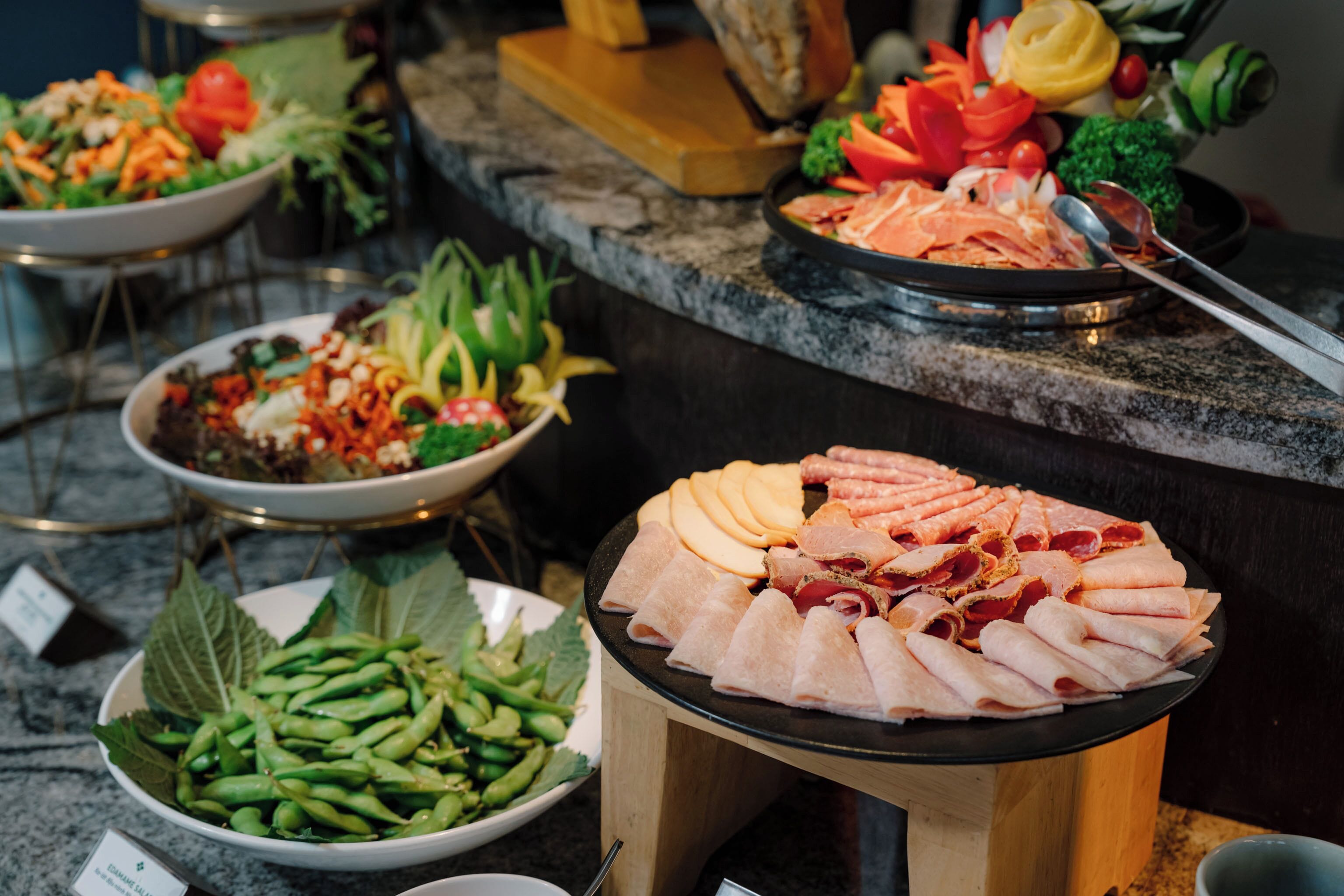 A buffet with various dishes including salads, meats, and vegetables.