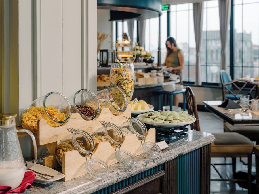 Ein Bereich mit einem Buffet und verschiedenen Speisen, im Hintergrund eine Person.