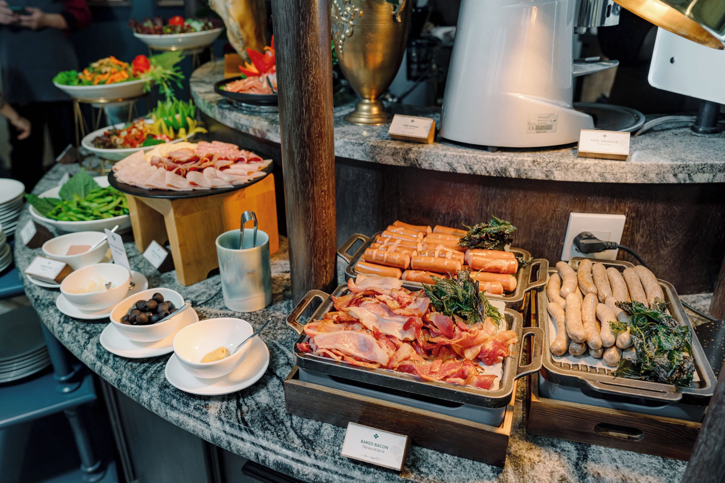 A buffet with various food items including meats, cheeses, and vegetables.