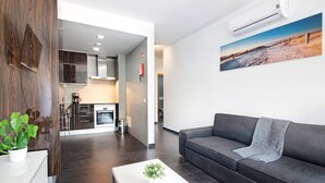 Ein modernes Wohnzimmer mit einem grauen Sofa, einem weißen Couchtisch und einem Gemälde an der Wand.