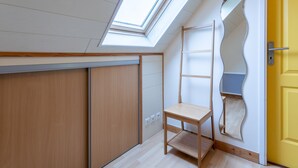 A room with a skylight, a wooden door, a mirror with a wavy frame, and a wooden chair. - Holiday Home 'Chez Fanch' with Private Terrace, Private Garden and Wi-Fi (Camaret-sur-Mer)