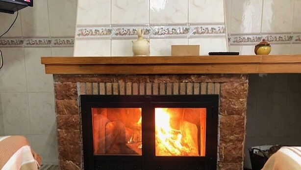 Una chimenea con revestimiento de piedra y salpicadero de azulejos.