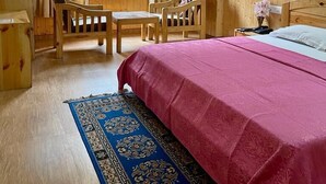 A room with a bed, wooden furniture, a window with curtains, and a ceiling fan. - Amar Villa Manali (Manali)