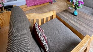 A hotel room with a bed, a ceiling fan, a TV, a wooden desk, a chair, and a small table with a vase of flowers. - Amar Villa Manali (Manali)