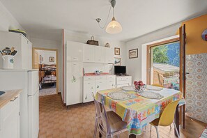 Een knus keuken met een eethoek, een televisie en uitzicht op de omgeving.