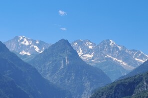 Une chaîne de montagnes aux sommets enneigés, sous un ciel bleu azur.