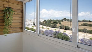 Una habitación con un ventanal amplio, un revestimiento de paneles de madera y una planta colgante.