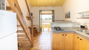 A kitchen with wooden cabinets, a gas stove, and a ceiling fan.