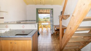 A kitchen with a wooden counter, a ceiling fan, and a view through an open door to an outdoor patio with a table and chairs. - Apartment 'Le Tre' with Sea View, Wi-Fi, and Air Conditioning (Appietto)