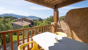 A balcony with a table and chairs, overlooking a scenic landscape with mountains and a body of water. - Apartment 'Le Tre' with Sea View, Wi-Fi, and Air Conditioning (Appietto)