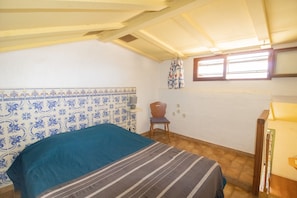 A bedroom with a bed, a chair, a window, and a wall with a decorative tile pattern. - Apartment 'Le Tre' with Sea View, Wi-Fi and Air Conditioning (Appietto)