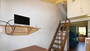 A room with a wooden desk, a mounted TV, a wooden ladder, and a bunk bed. - Apartment 'Le Tre' with Sea View, Wi-Fi, and Air Conditioning (Appietto)