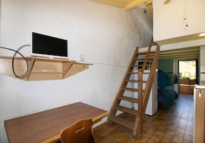 A room with a wooden desk, a mounted TV, a wooden ladder, and a bunk bed. - Apartment 'Le Tre' with Sea View, Wi-Fi and Air Conditioning (Appietto)