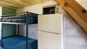 A dormitory room with bunk beds, a microwave, and a refrigerator. - “Le Cinque” Apartment with Sea View, Wi-Fi, and Air Conditioning (Appietto)
