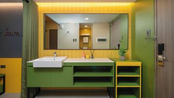 Un baño moderno con un tocador verde, un lavabo blanco y un espejo.