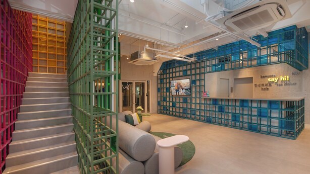 A modern interior with a staircase, green and blue seating areas, and a reception desk. - lyf Malate Manila managed by The Ascott Limited (Manila)