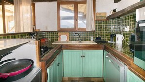 A kitchen with a window, a sink, a stove, and a dishwasher.