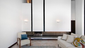 A modern living room with a sofa, armchair, and a fireplace. - Vacation Home "Vilamoura Com Piscina E Wifi" with Private Pool, Terraces & Wi-Fi (Vilamoura)