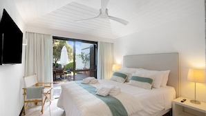 A hotel room with a large bed, a ceiling fan, a TV, a desk with a lamp, and a view of the outdoors. - Vacation Home "Vilamoura Com Piscina E Wifi" with Private Pool, Terraces & Wi-Fi (Vilamoura)