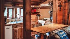 A cozy cabin-style kitchen with wooden cabinets, a stove, and a sink. - Romantic Cabin | Private Stay | King Bed | Fire Pit (Rockbridge)