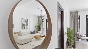 A modern living room with a sofa, coffee table, and a large mirror reflecting the space. - Silkhaus Zaafaran, Downtown Dubai (Dubai)