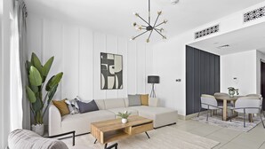 A modern living room with a sofa, coffee table, and a dining area with a table and chairs. - Silkhaus Zaafaran, Downtown Dubai (Dubai)