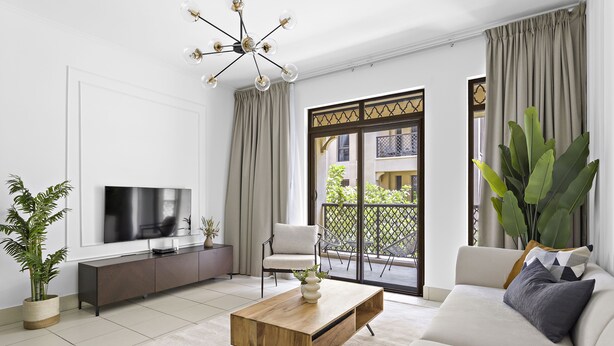 A modern living room with a sofa, coffee table, TV, and a balcony with plants. - Silkhaus Zaafaran, Downtown Dubai (Dubai)