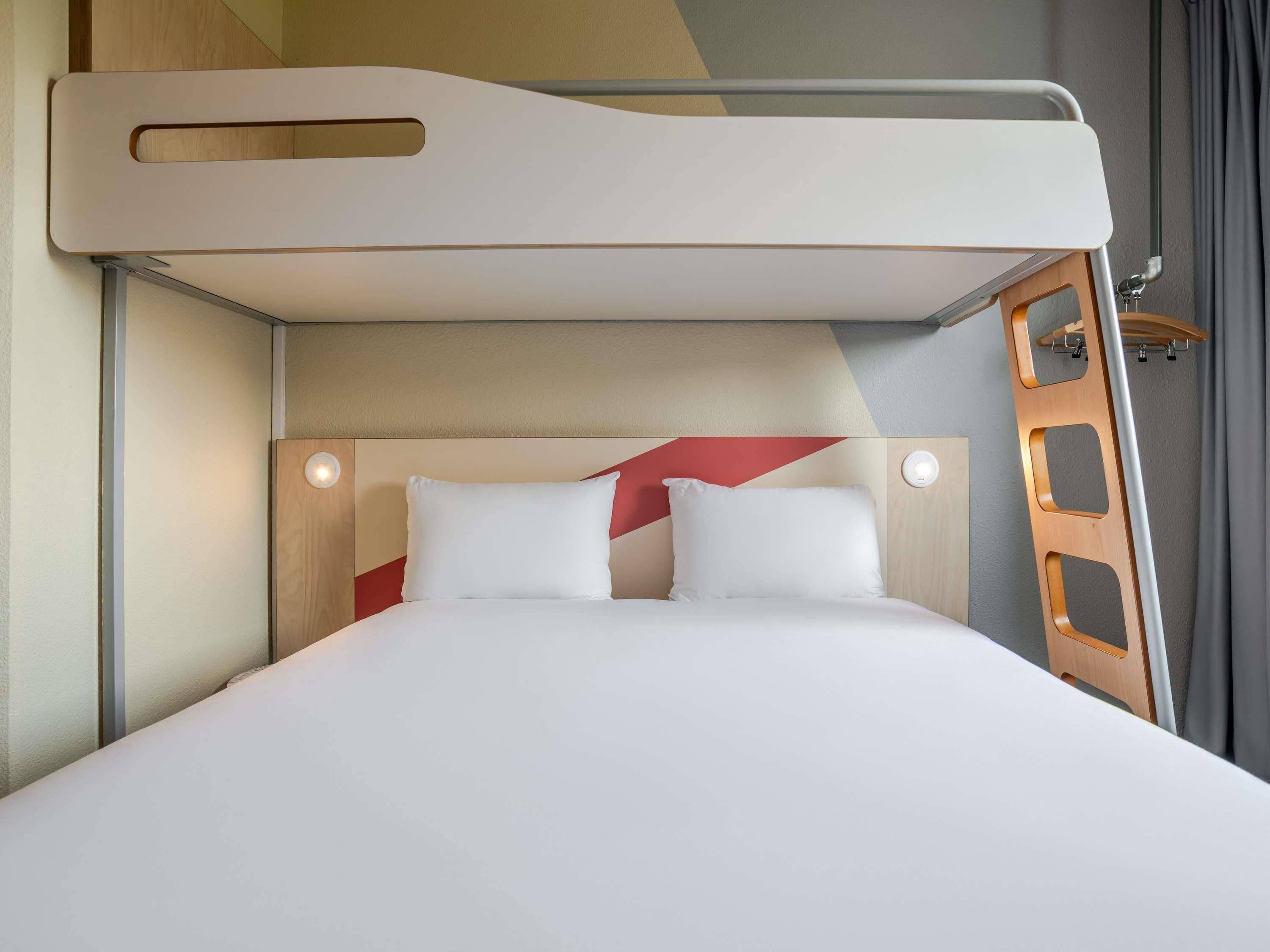 Una cama litera con cabecera y escalera.