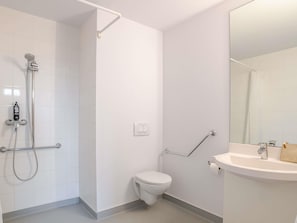 A bathroom with a shower, toilet, and sink.