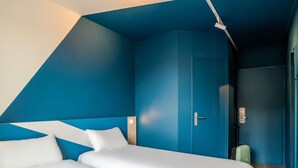 A room with a bed, a door, and a suitcase. - ibis budget Bordeaux Sud Villenave-d'Ornon (Villenave-d'Ornon)
