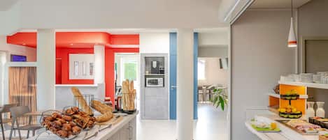 A modern kitchen with a central island, a dining area with chairs, and a bright pendant light.