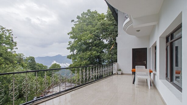 A balcony with a view of mountains and trees. - Itsy Hotels Peak View, 300 Mts From Mall Road (Mussoorie)