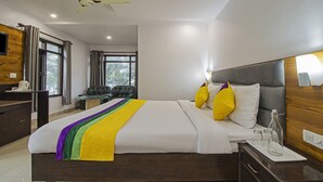 A hotel room with a large bed, a desk, a chair, and a window. - Itsy Hotels Peak View, 300 Mts From Mall Road (Mussoorie)