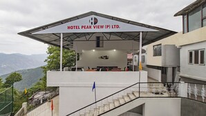 A hotel named "HOTEL PEAK VIEW (P) LTD." with a covered terrace and a staircase leading to the entrance. - Itsy Hotels Peak View, 300 Mts From Mall Road (Mussoorie)