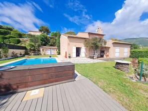 Una casa con piscina, patio e giardino.