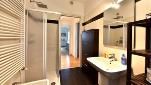 A modern bathroom with a shower, sink, and mirror. - GuestHost - Casa Kikka: luminoso bilo con balcone (Cernusco sul Naviglio)