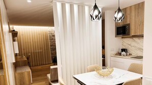 Een moderne eethoek met een marmeren tafel, beige stoelen en hanglampen.