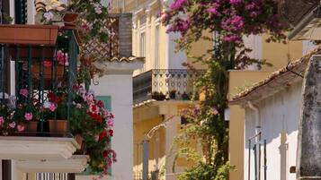 Un edificio con balcones decorados con flores y una reja de hierro forjado.