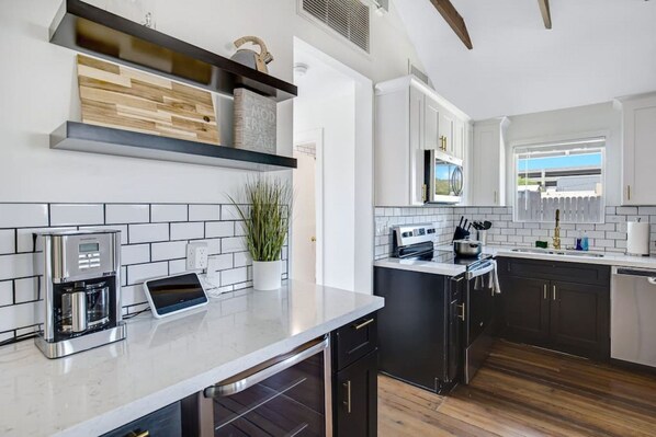 Una cocina moderna con cafetera, horno integrado y ventana con vistas.
