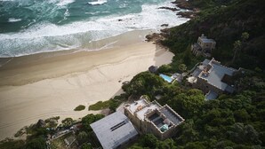 A coastal property with a beach, a stone building, and a pool. - Buccara Noetzie - Craighross Castle (Knysna)