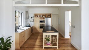 Une cuisine moderne avec des meubles en bois, un plan de travail noir et un îlot central.