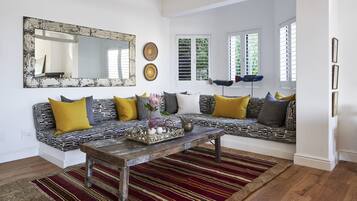 Una sala de estar moderna con un sofá estampado, una mesa de centro de madera y un tapete a rayas.