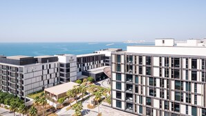 A modern building with multiple floors, large windows, and a view of the ocean. - Luxury 2BR plus maids room in Bluewaters (Dubai)