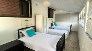 A narrow corridor with two beds, a wooden bench, and a small table. - Summer Beach House Spiaggia (Pyrgos)