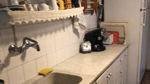 A kitchen with a sink, cabinets, a coffee maker, and a refrigerator. - Summer Beach House Spiaggia (Pyrgos)