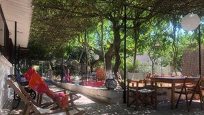 An outdoor patio with wooden furniture, a table, and chairs. - Summer Beach House Spiaggia (Pyrgos)